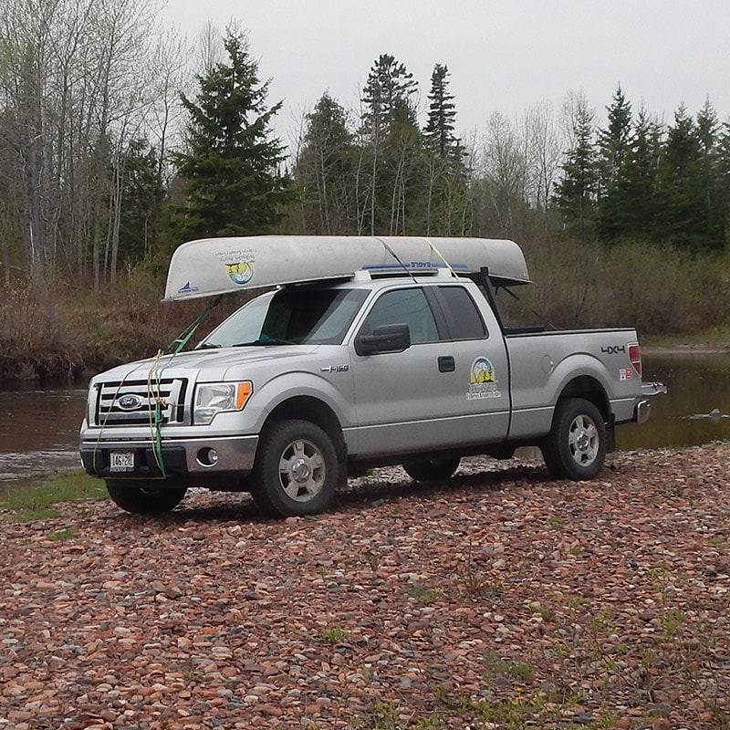 Pickup truck with boat strapped to the roof